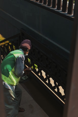 Craftsman applying a fresh coat of paint to a wooden staircase in a Swiss home.