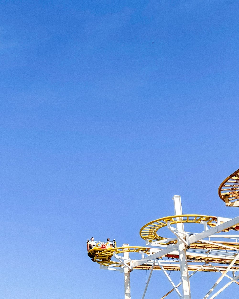 white and yellow ferris wheel under blue sky during daytime