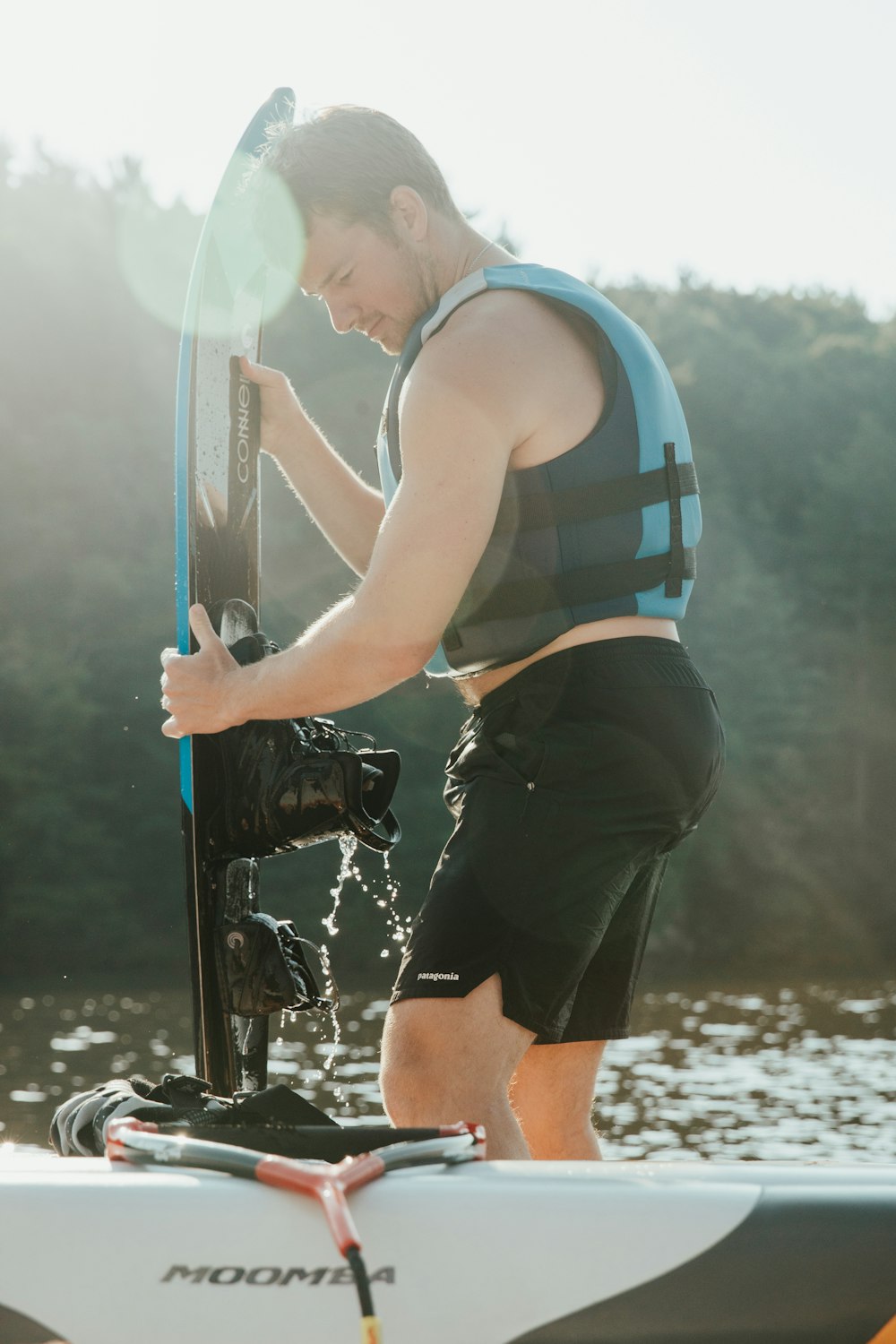 man in blue and white striped tank top and black shorts holding black and white fishing