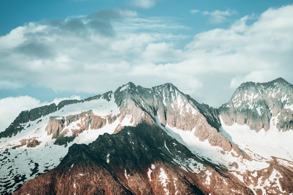 snow covered mountain under cloudy sky during daytime