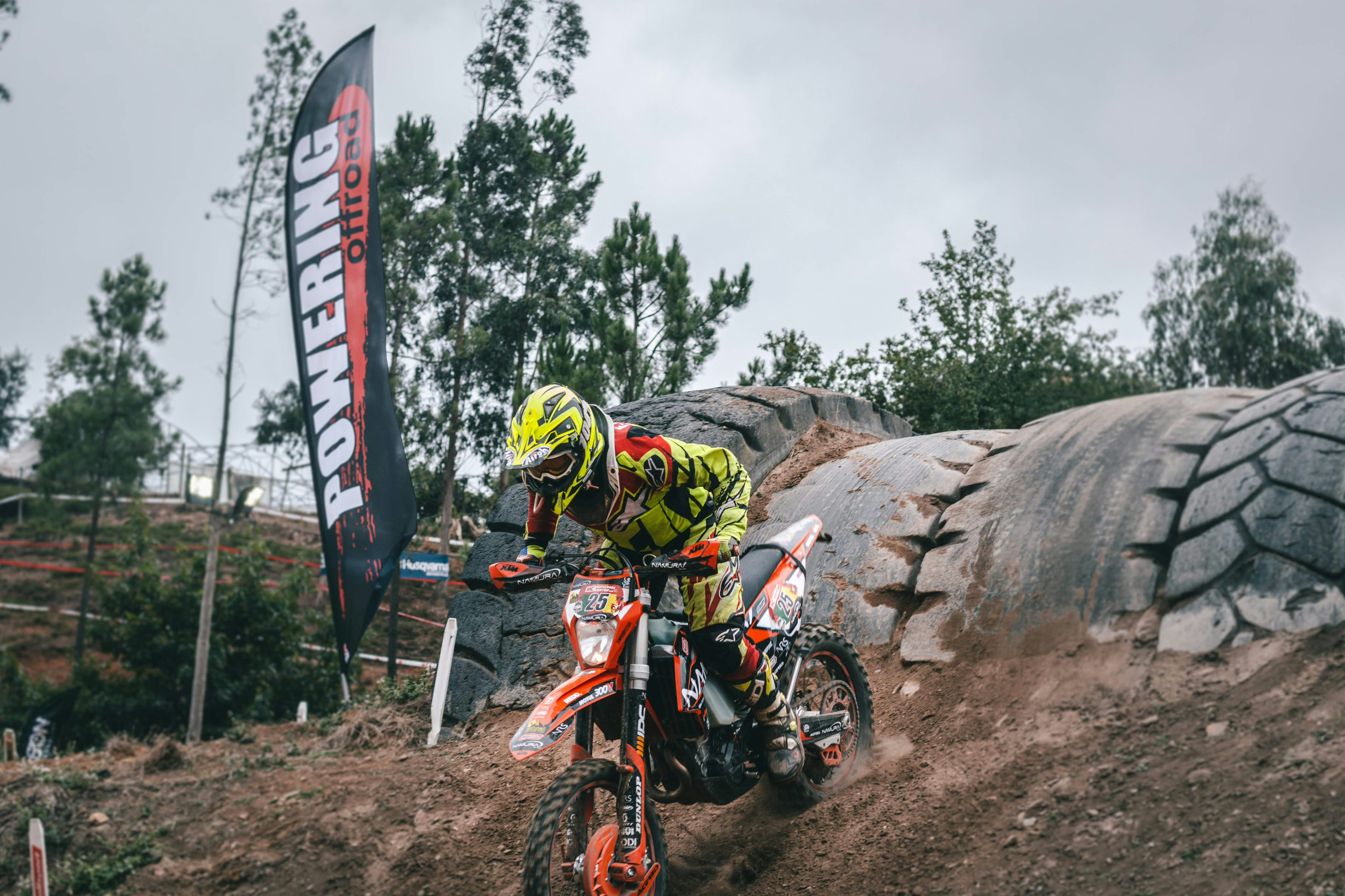 man in green and yellow racing suit riding motocross dirt bike doing racing during daytime