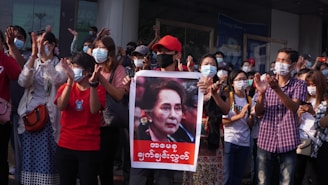 people holding red and white banner