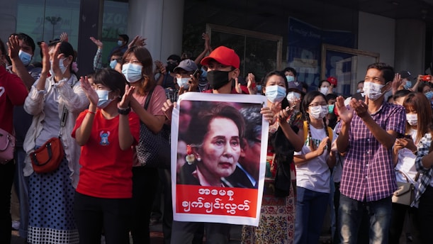 people holding red and white banner