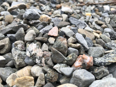 Close-up of various gravel types neatly arranged in natural earthy tones.