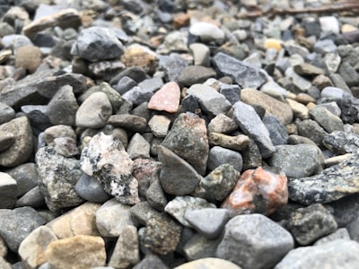 Close-up of clean, sharp 20 mm stones and washed sand neatly piled at a supply yard.