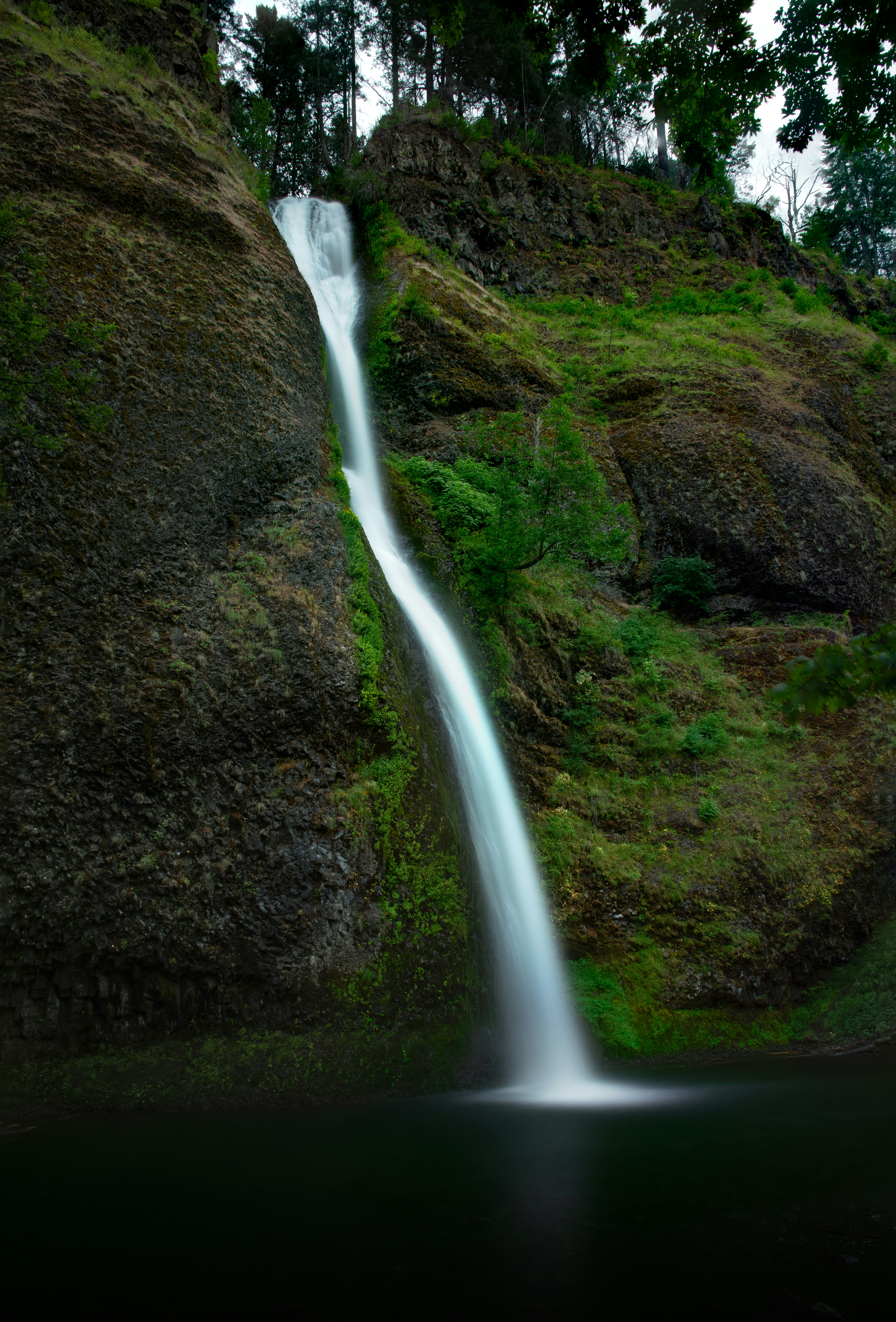 water falls in the middle of green grass field