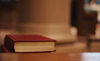 Close-up of a sleek sci-fi novel cover with turquoise accents resting on a wooden table.