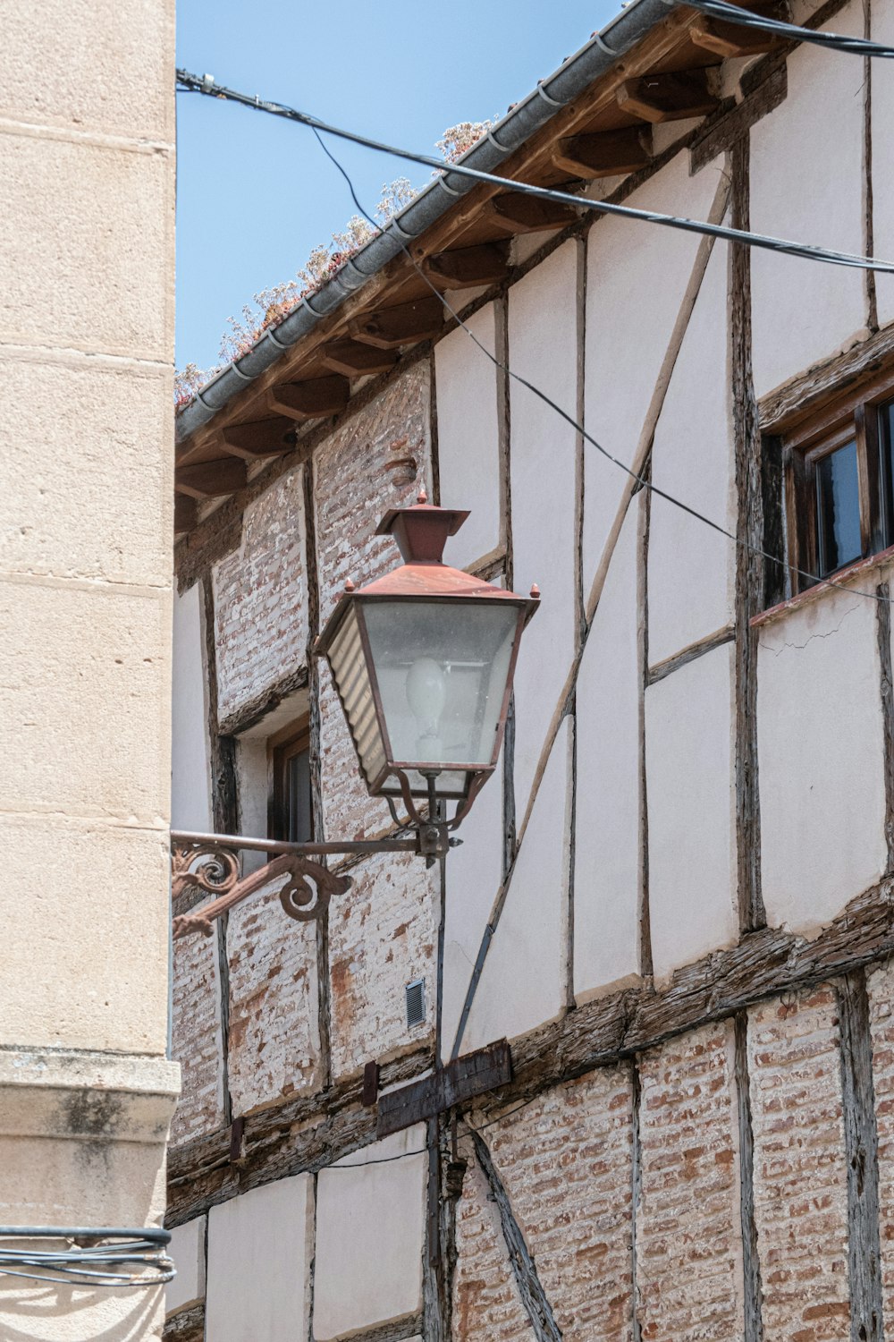 black metal framed red lamp post on brown concrete building during daytime