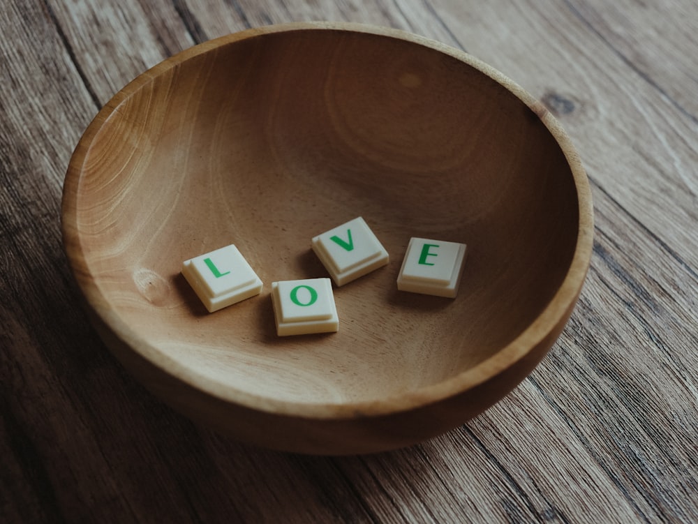 white and brown letter blocks on brown wooden round plate