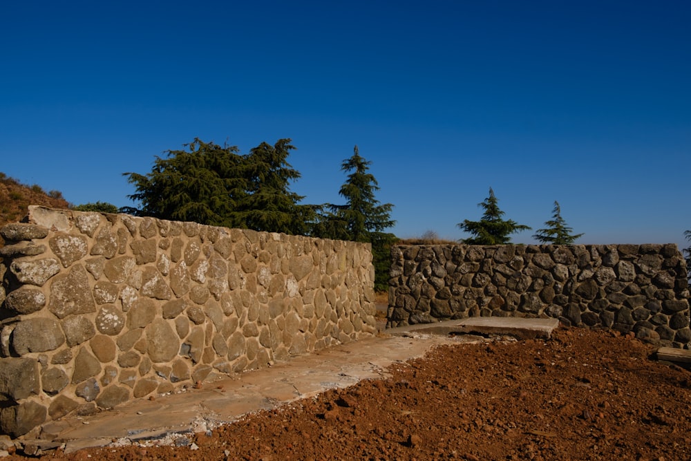 muro di mattoni marrone e grigio sotto il cielo blu durante il giorno