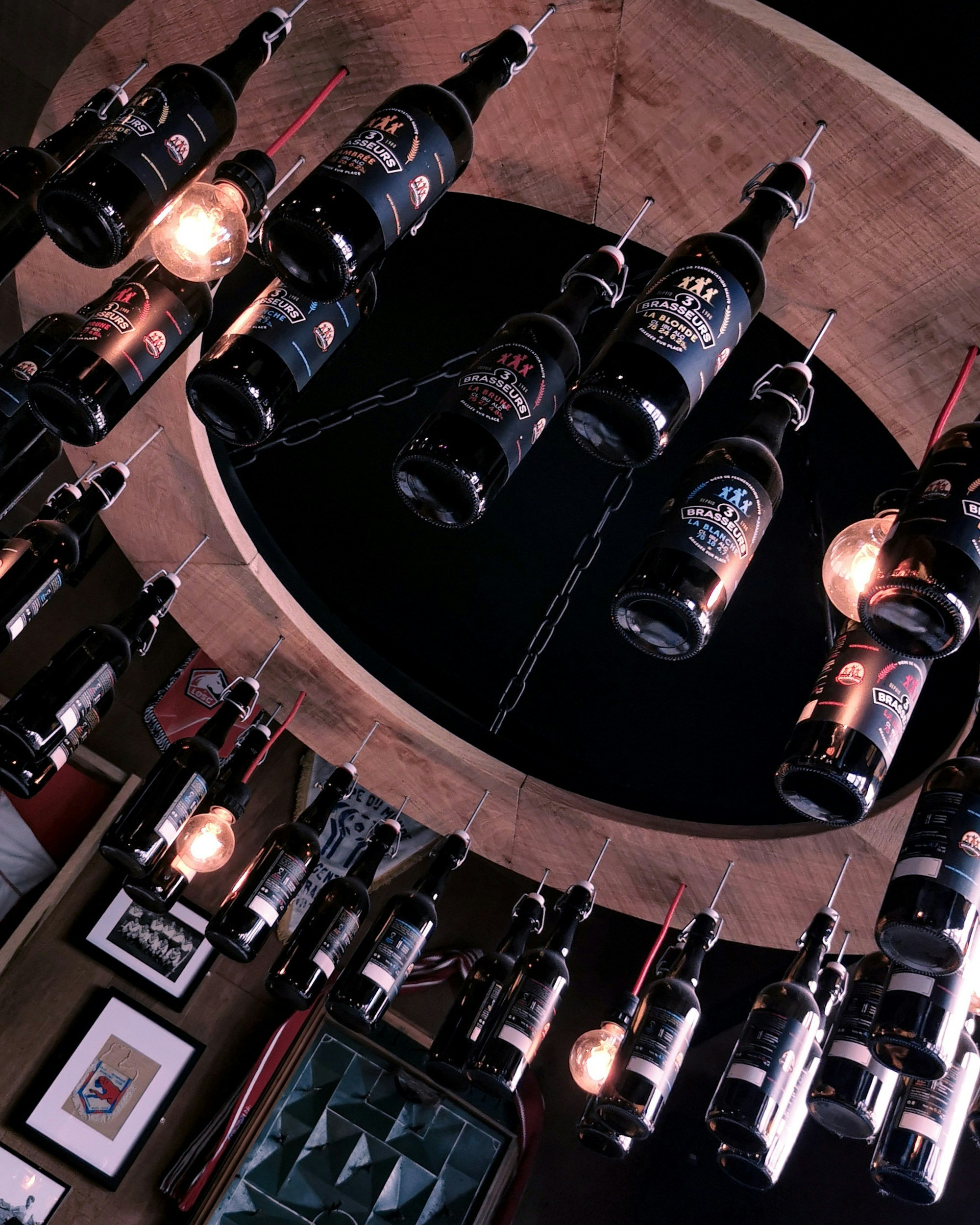 Brewery restaurant interior at night, dim warm Edison bulbs, exposed brick and timber, dark atmospheric industrial ambiance