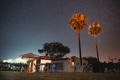white and blue wooden house near green trees under blue sky during daytime