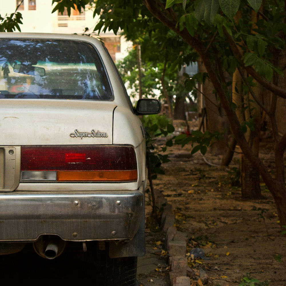 carro chevrolet branco estacionado ao lado da árvore