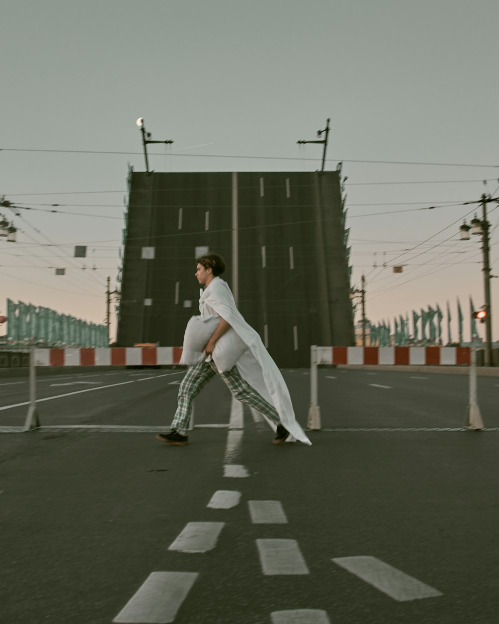 man in white shirt and pants walking on the road