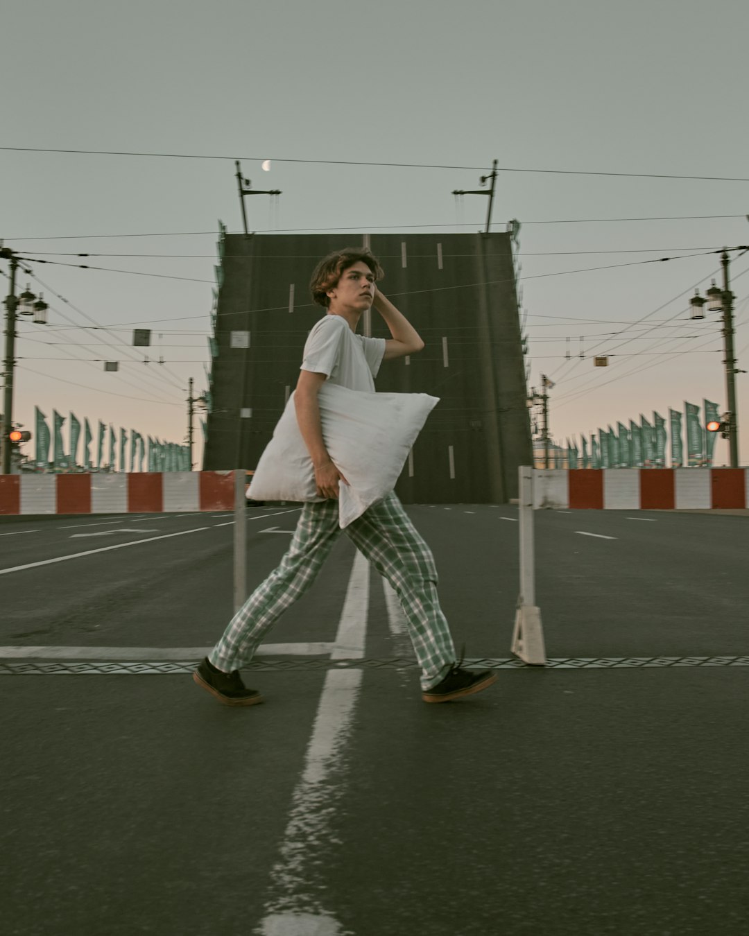 woman in white long sleeve shirt and gray pants standing on black asphalt road during daytime