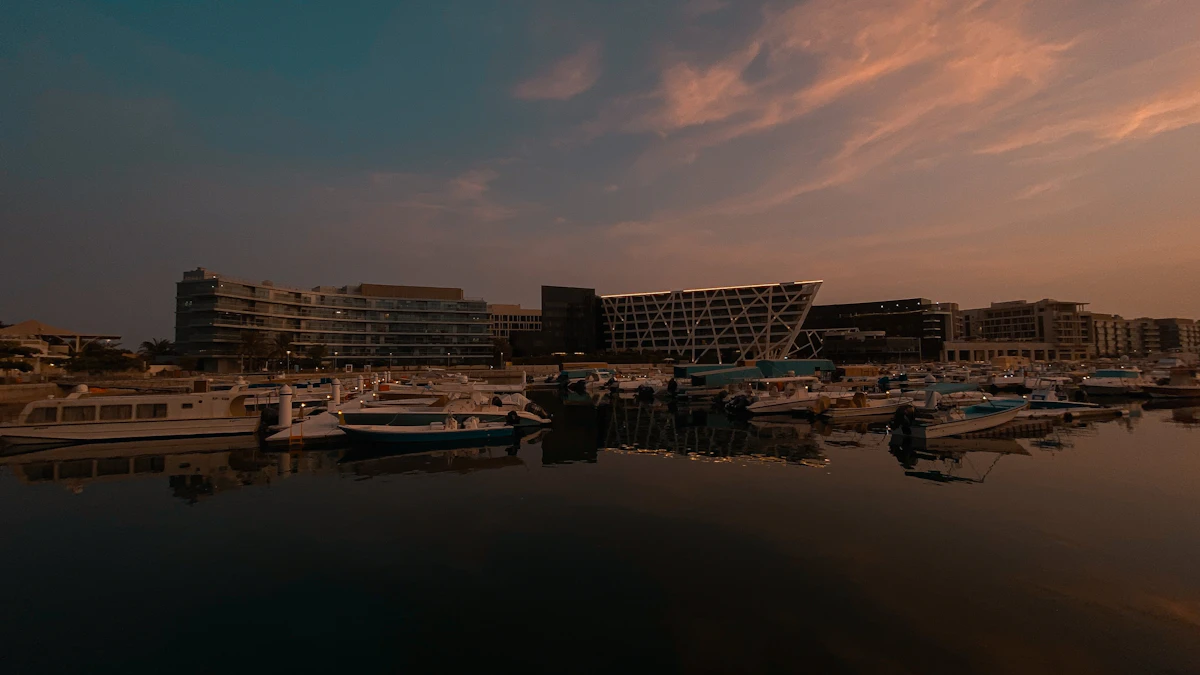 A white boat on the water near city buildings at sunset in Abu Dhabi