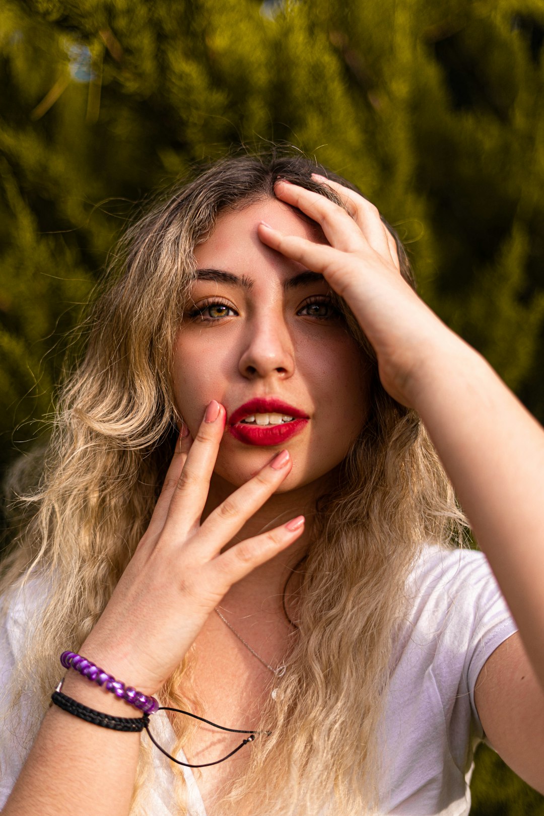 woman in white shirt with red manicure