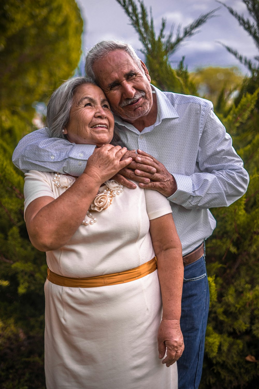 man in white dress shirt hugging woman in white dress