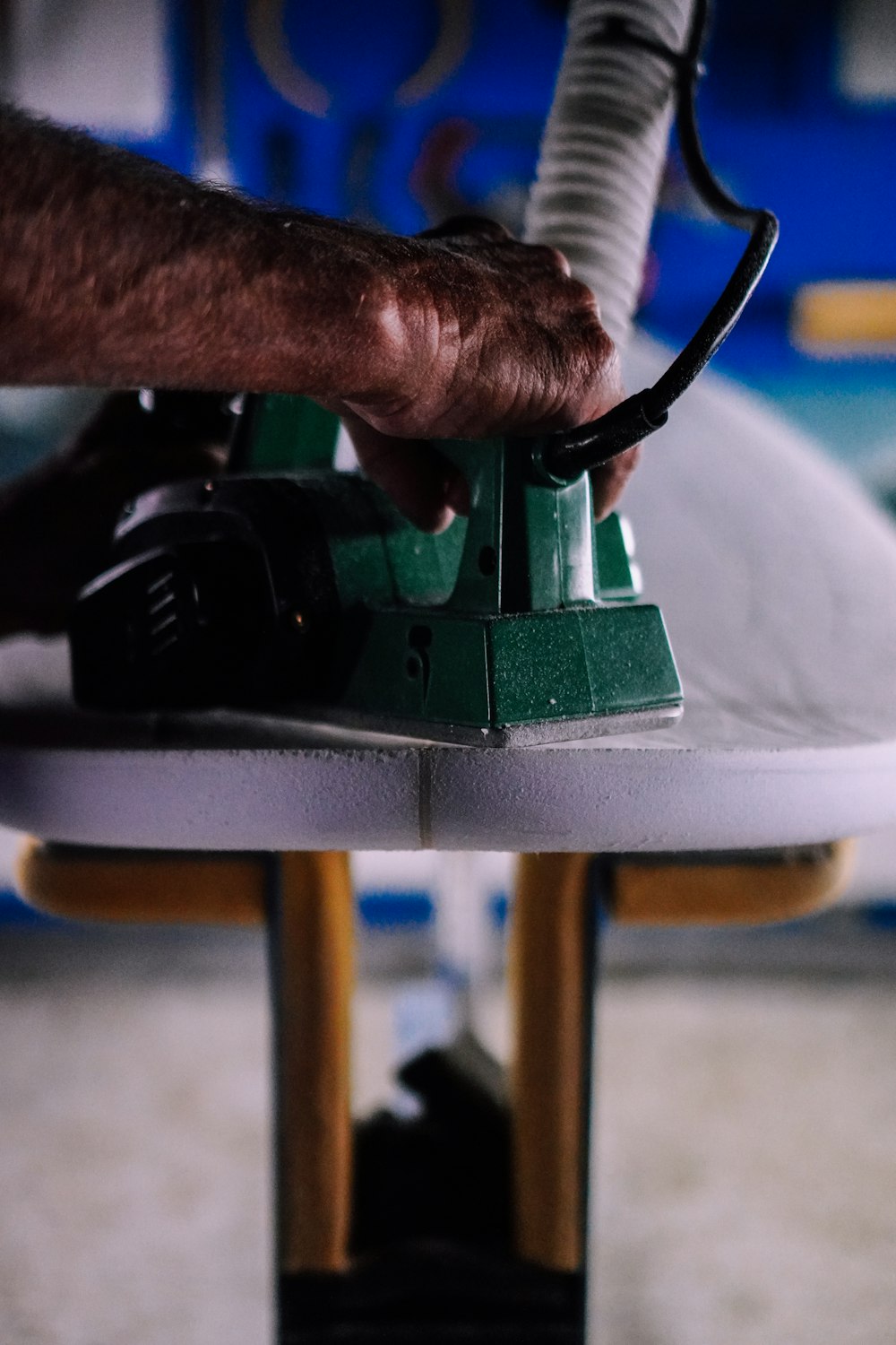 person using green and black power tool