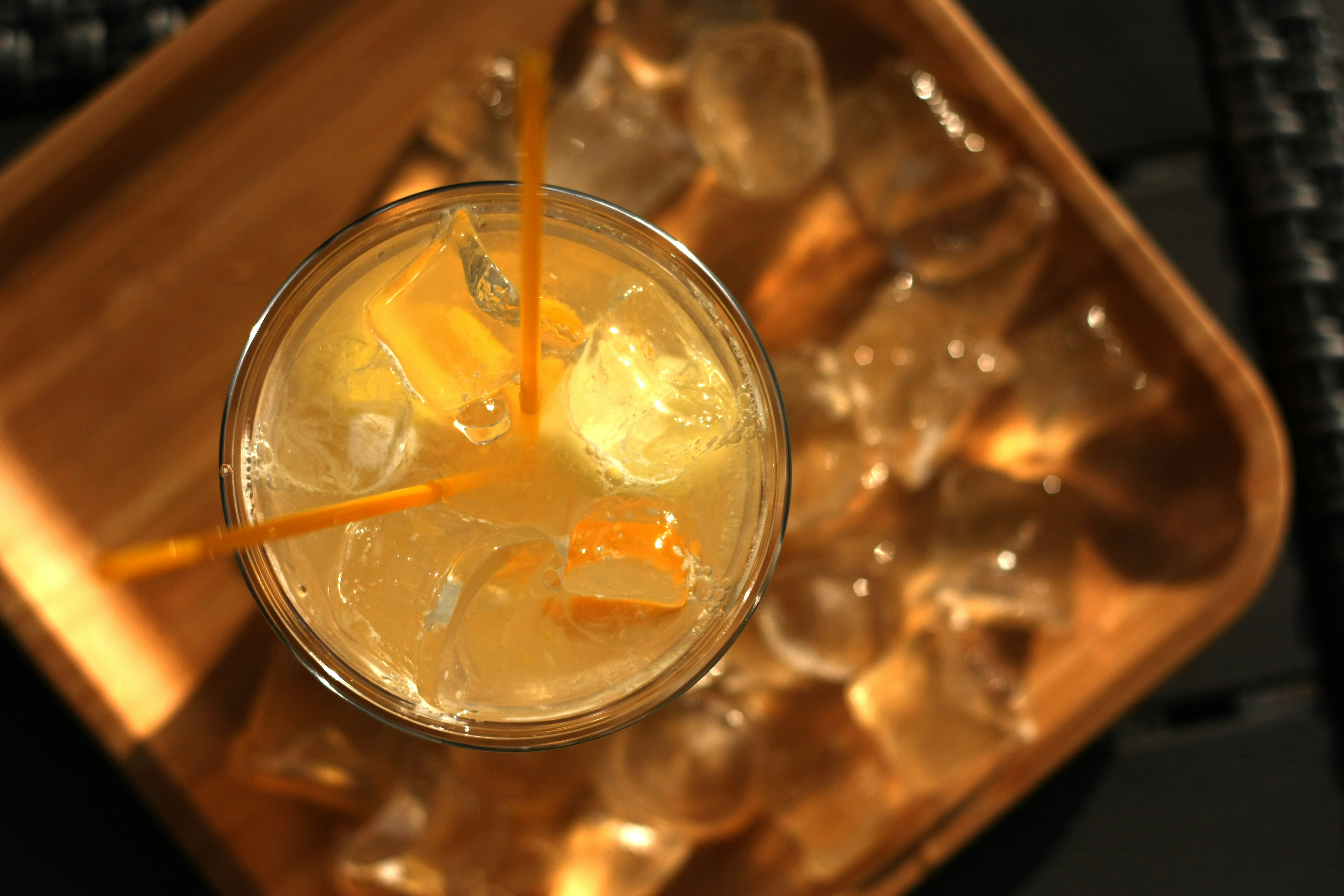 Overhead citrus cocktail with straw on ice tray