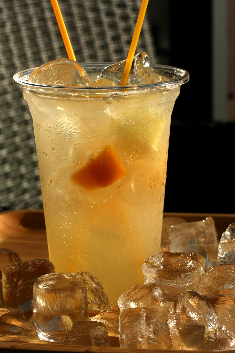 verre à boire transparent avec liquide jaune et glaçons