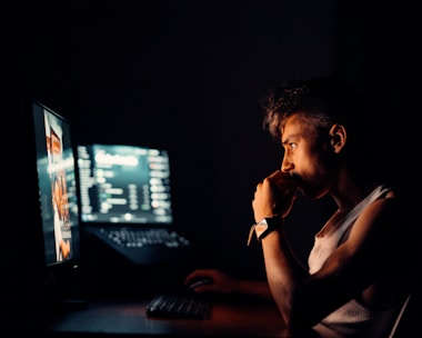 A person checking a computer monitor for activity.