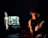 IT specialist monitoring database security on multiple screens in a dark room.