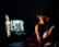 IT specialist monitoring database security on multiple screens in a dark room.