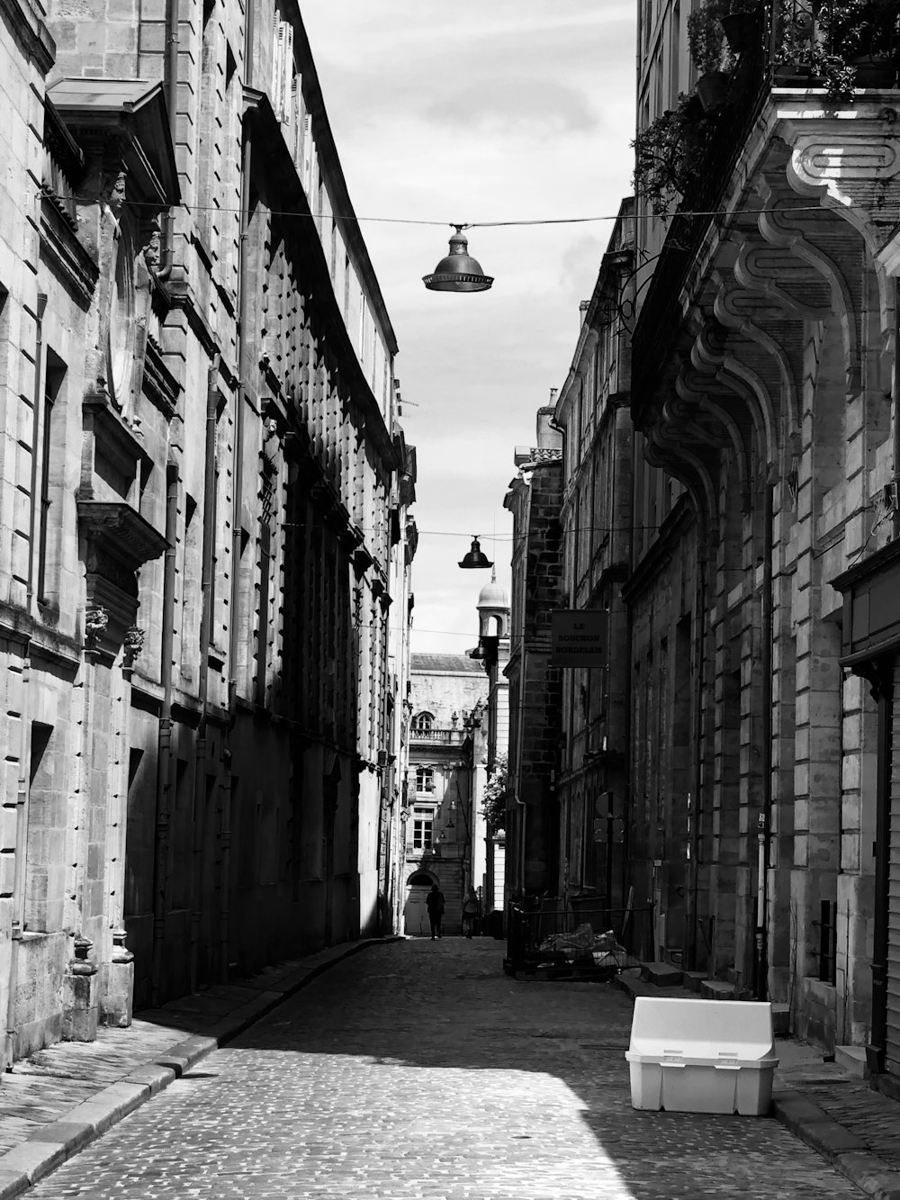 grayscale photo of street lamp between buildings