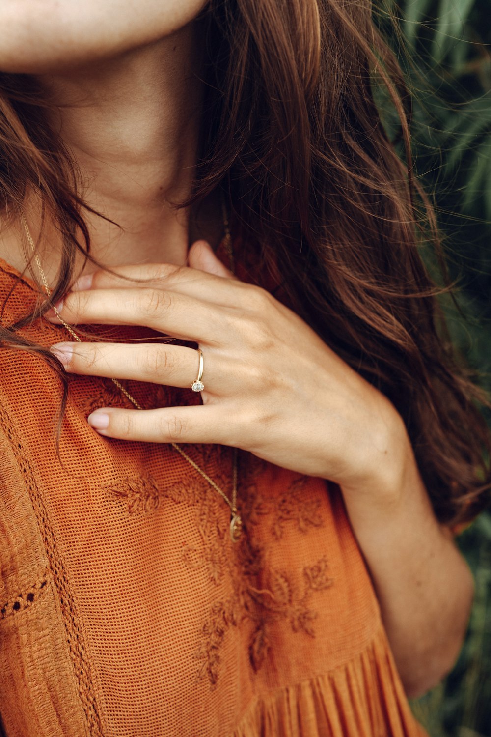 woman wearing silver ring and orange knit shirt