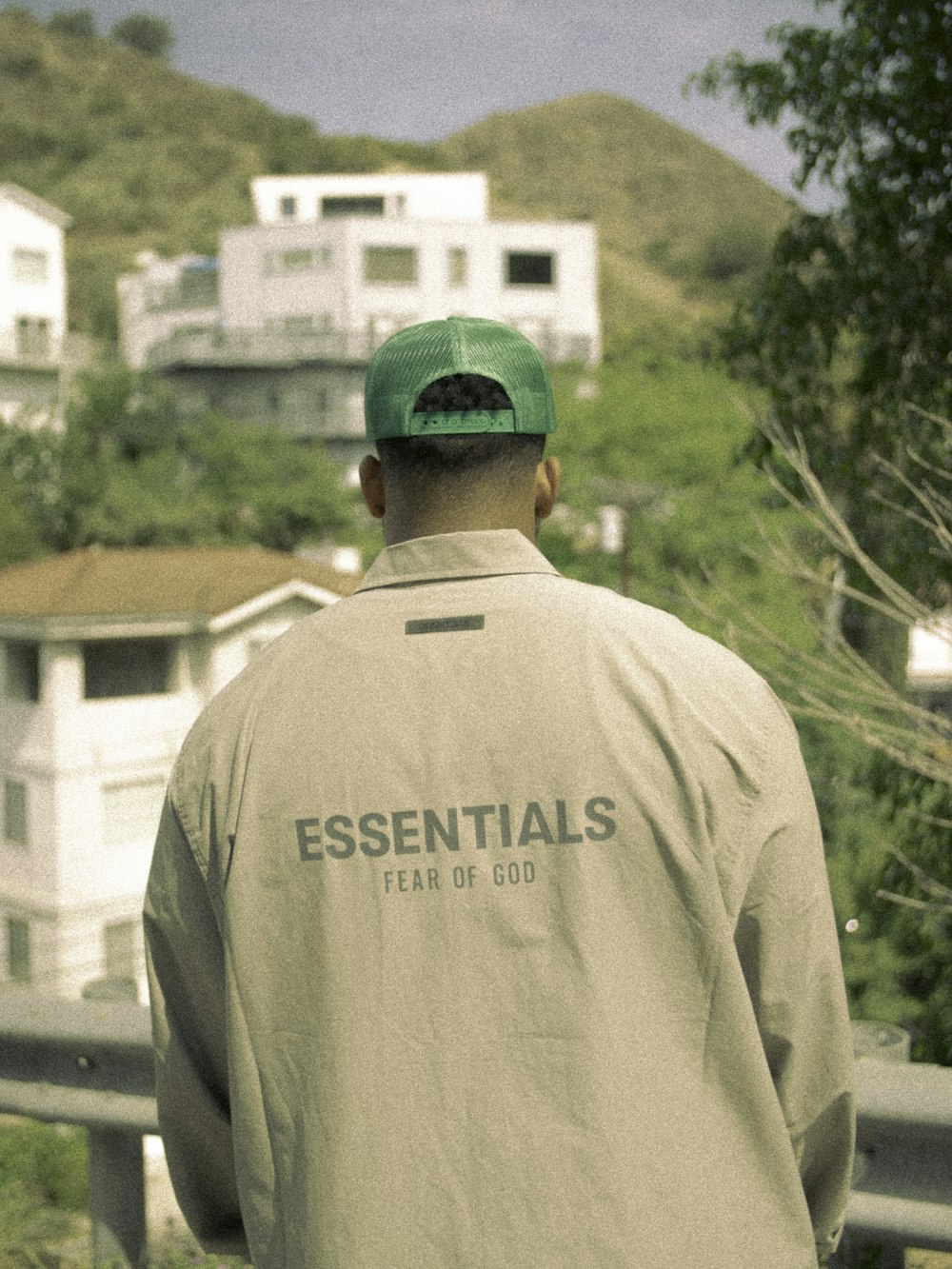 man in white crew neck t-shirt standing near green trees during daytime