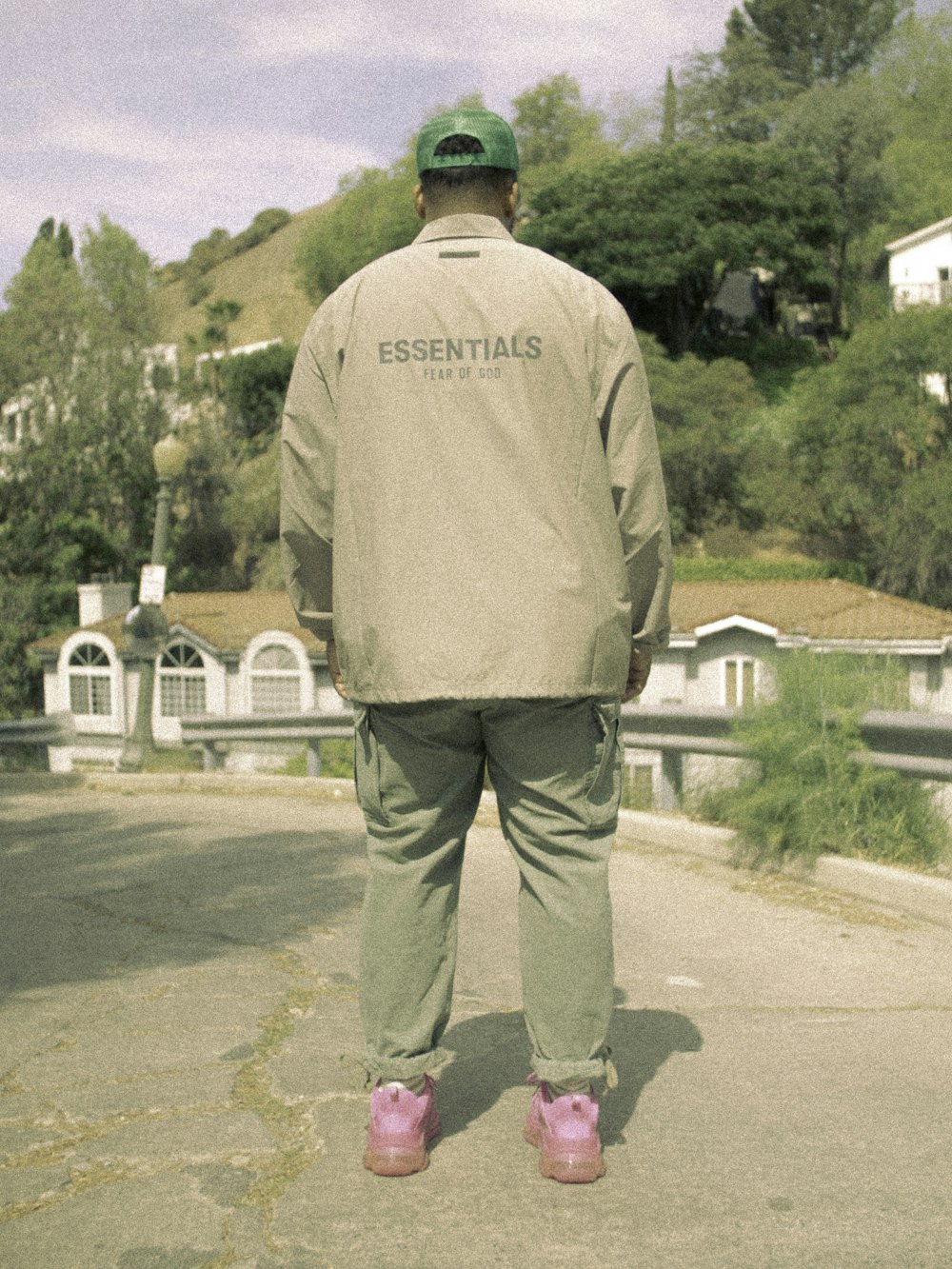 man in gray long sleeve shirt and gray pants standing on gray asphalt road during daytime