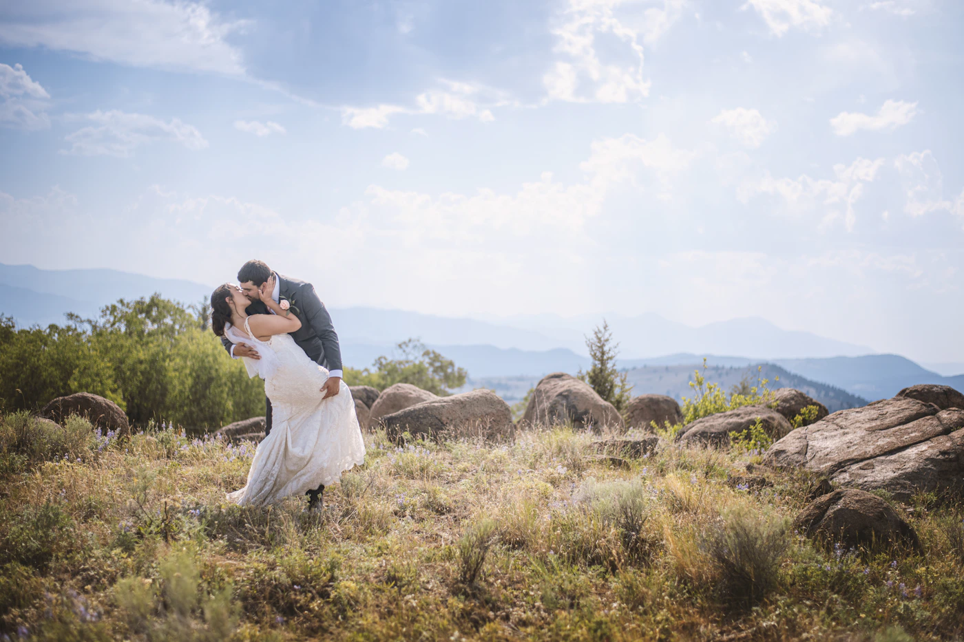 Couple in elopement ceremony attire in the Banff area of the Canadian Rockies with the turquoise glacial lake and the surrounding peaks visible during their ceremony