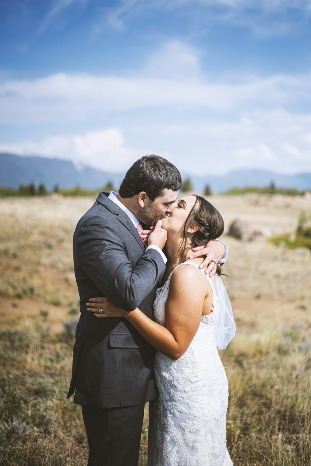 Uomo in abito nero che bacia la donna in abito da sposa bianco