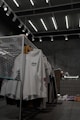 white polo shirt hanging on gray metal rack