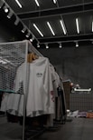 white polo shirt hanging on gray metal rack