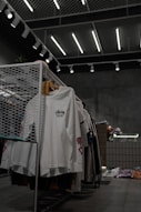 white polo shirt hanging on gray metal rack
