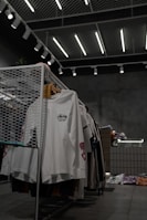 white polo shirt hanging on gray metal rack