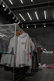 white polo shirt hanging on gray metal rack