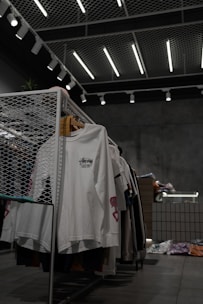 white polo shirt hanging on gray metal rack
