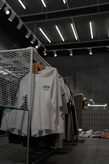 white polo shirt hanging on gray metal rack