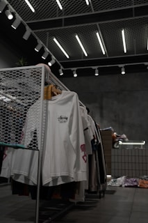 white polo shirt hanging on gray metal rack