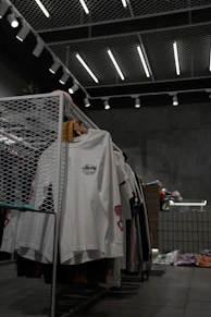 white polo shirt hanging on gray metal rack