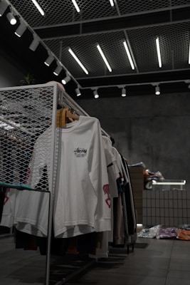 white polo shirt hanging on gray metal rack