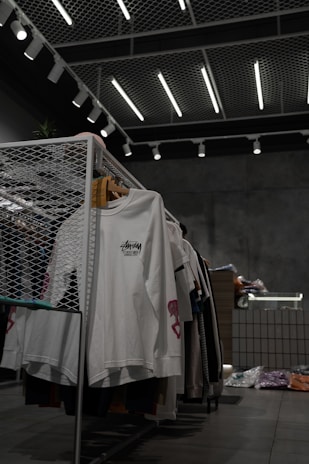 white polo shirt hanging on gray metal rack