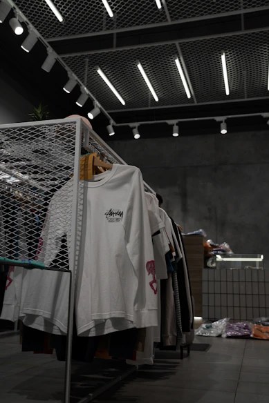 white polo shirt hanging on gray metal rack