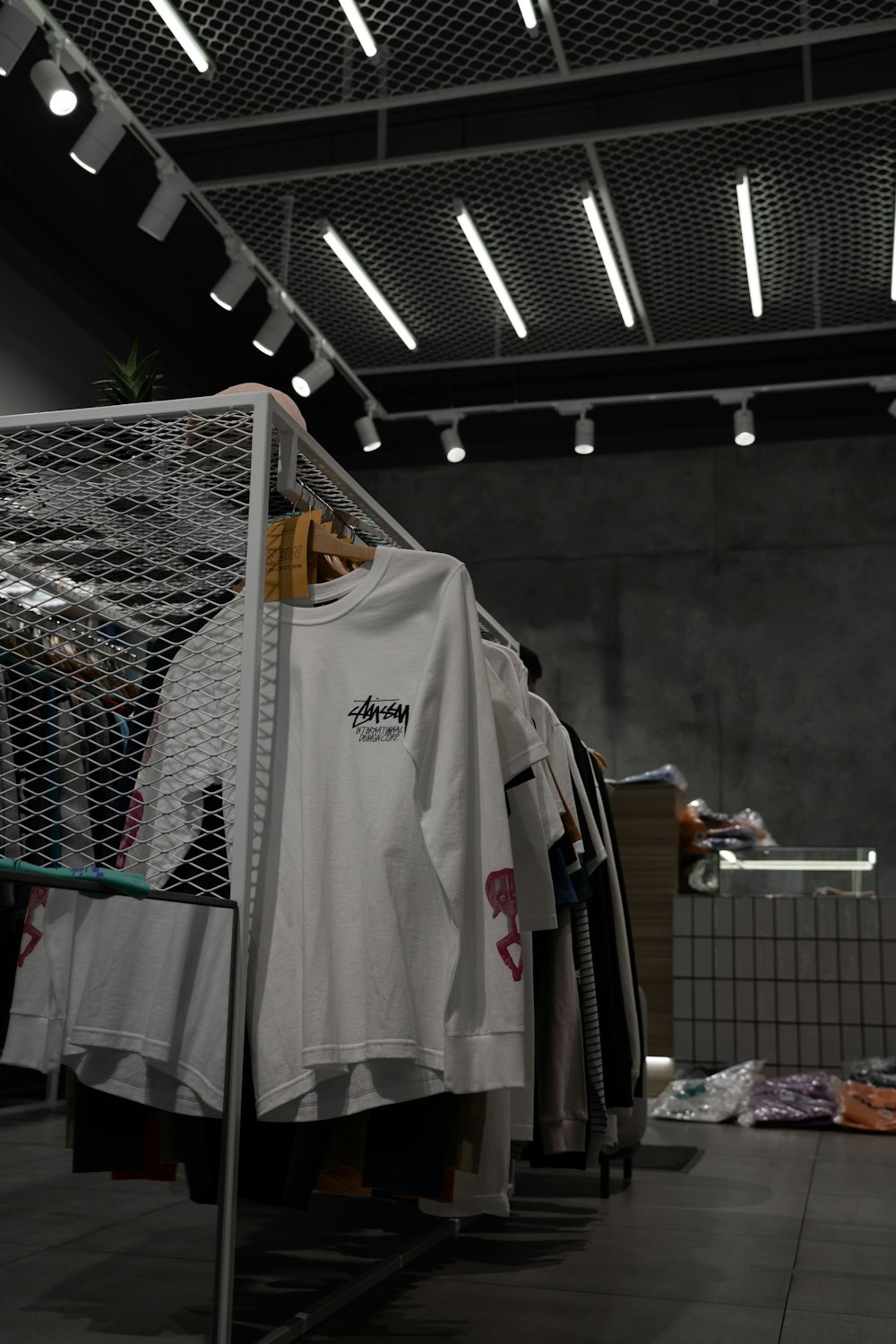 white polo shirt hanging on gray metal rack