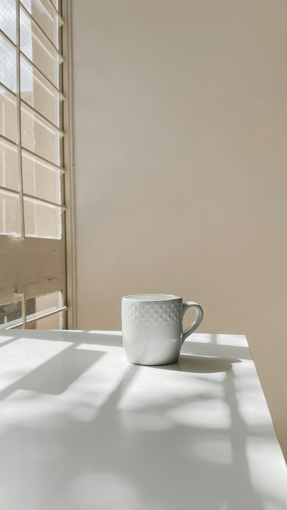 white ceramic mug on white table