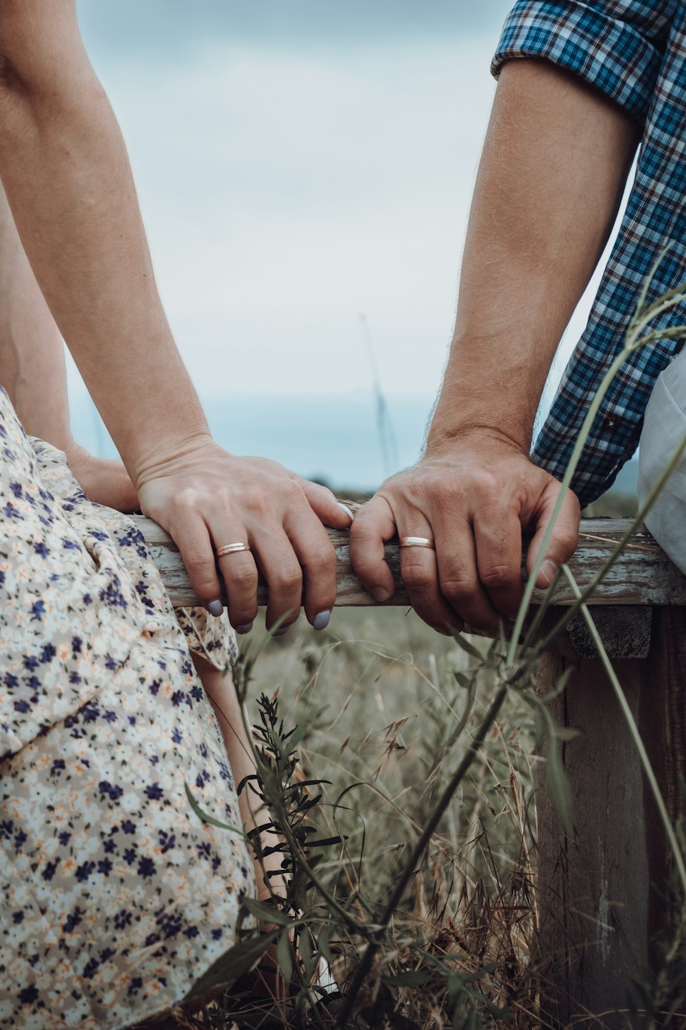 person in white and blue floral dress holding hands