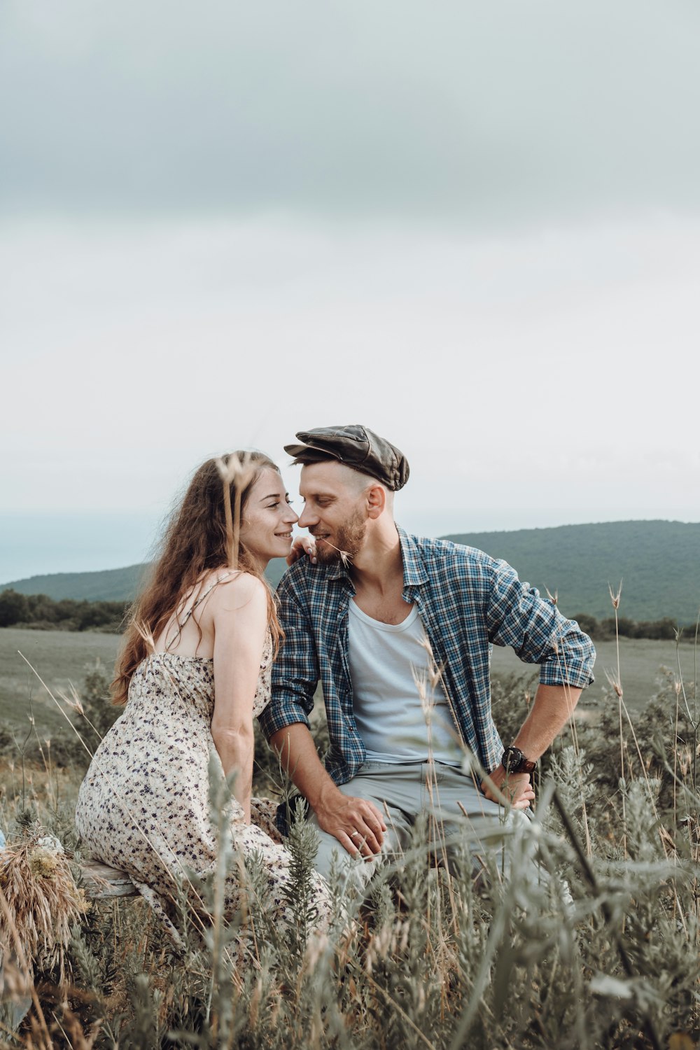 man and woman kissing on grass field during daytime